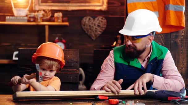 Отец и сын на работе. Родители помогают ребенку в мастерской. Концепция Дня счастливых отцов. — стоковое видео