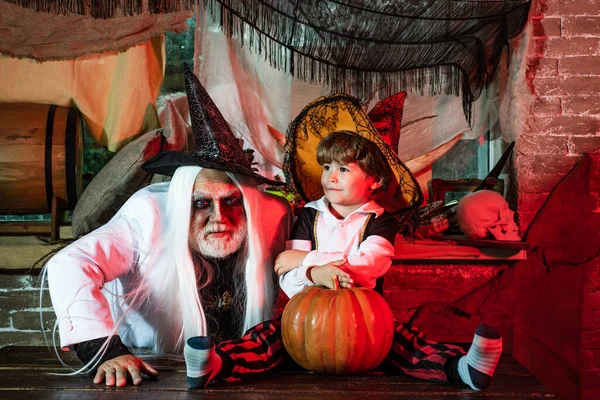 Vader en zoon spelen enge Halloween spelletjes thuis. Vader en zoon in carnaval kostuums wachten op gasten en snoep. Familie feest met Halloween. Halloween thuis. — Stockfoto