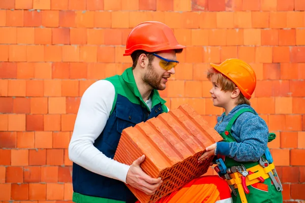 Bricklayer make masonry, builder work with brick layer. Brothers at work. Small child boy repairing in workshop.