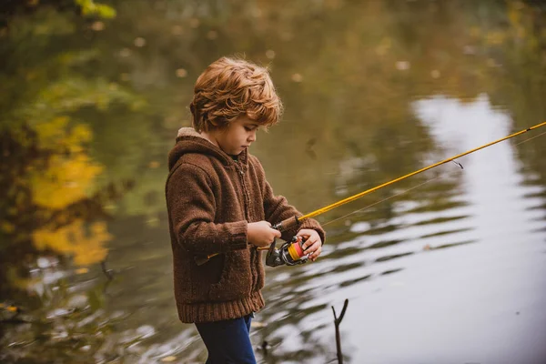 Pequeño pescador. Niño pescando en mono desde un muelle en el lago o estanque. — Foto de Stock