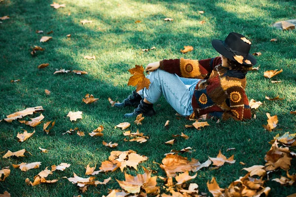 Grande feuille d'érable à la main féminine. Femme tenant des feuilles d'érable d'automne. Automne fille dans le parc de la ville. Feuilles jaunes tombées. — Photo