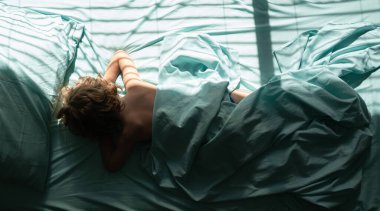 Çocuklar uzanır ve yastığın üzerinde uyur. Sabahları yatak odasında rahat bir şekilde uyuyan çocuk manzarası..