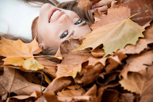 Beztroska szczęśliwość. Szczęśliwa jesień, piękna dziewczyna leży w klon, żółte liście. — Zdjęcie stockowe