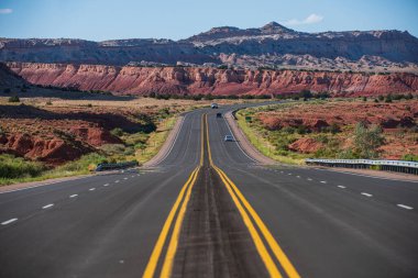 Monument Valley Yolu. Yaz mevsiminde tarlalar arasında asfalt yol.