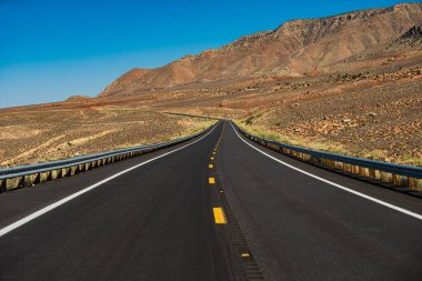 Asfalt desenli, arka planda. Kaliforniya 'nın Yucca Vadisi' ndeki Route 66 'da Mohave Çölü. Amerikan yol gezisi.