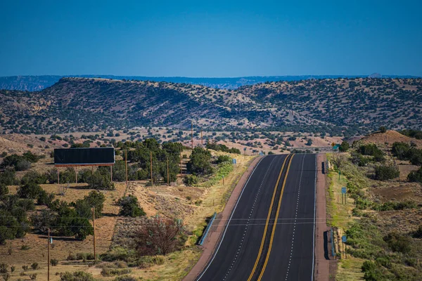 Landscape with rocks, sunny sky and asphalt road in the evening in summer. Road trip, travel background. — Stock Photo, Image