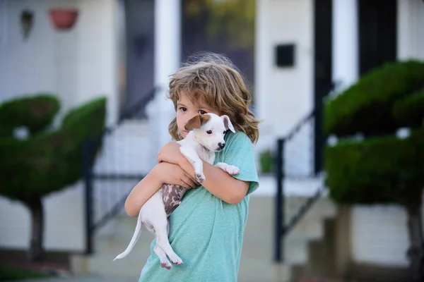 Funny photo of happy kids hugging beautiful puppy dog. Lovely child with dog walking outdoor. — Stock Photo, Image