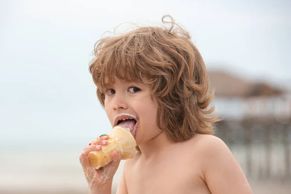Un ragazzino che mangia gelato. Funy bambino riccio con gelato all'aperto. — Foto Stock