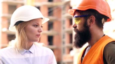 Portre işçisi ve mühendis teftiş altında ve fabrika istasyonundaki üretim sürecini kontrol ediyorlar. İnşaatçılar inşaat alanında iletişim kuruyor..