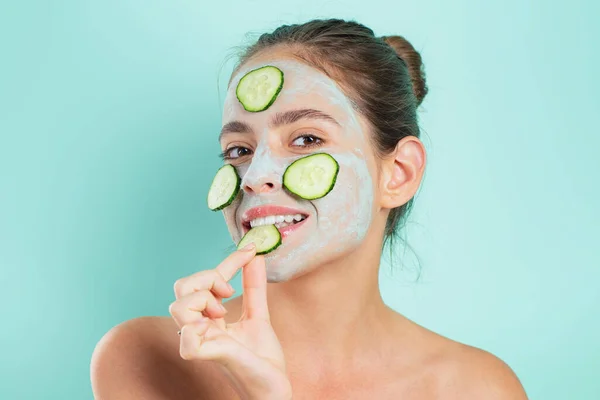 Belleza natural. Chica escalofriante haciendo mascarilla facial de arcilla con pepino. Salud de la piel. Mujer adorable bonita chica sonriente con máscara de arcilla. — Foto de Stock