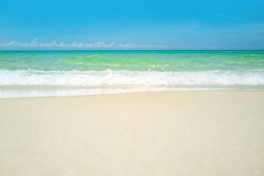 Tropikal sahildeki sakin deniz sahilinin üzerinde mavi gökyüzü olan bulutlar. Mavi gökyüzü ve kumlu deniz kumsalı. Güzel deniz yazı ya da bahar soyut arkaplanı.