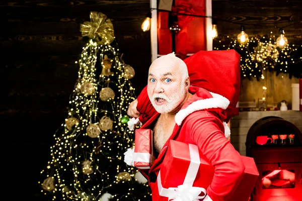 Einbrecher in Weihnachtsmannkleidung mit Nikolausmütze Dieb Weihnachtsmann mit Tasche auf Weihnachtshintergrund. Dieb stahl Neujahrsgeschenke Weihnachtsmann in der Maske mit Sack. — Stockfoto