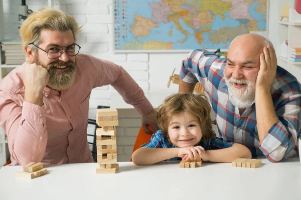 Otec a syn s dědečkem byli nadšení z hraní hry. Otec a syn hrají Jengu s vnoučátkem. — Stock fotografie