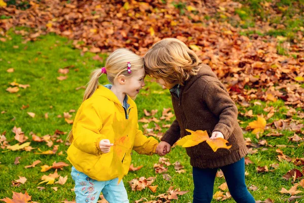 Dos hermanos alegres hermano y hermana abrazándose y abrazándose en el parque de otoño. —  Fotos de Stock