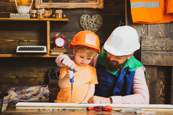 Vader leert zijn zoon de schroevendraaier en hamer te gebruiken. Werken met gereedschap bouw. Concept voor kindergroei. — Stockfoto