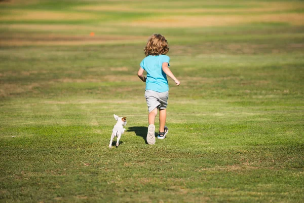 Glückliche Kinder laufen mit einem Hund im Freien. Laufhund. — Stockfoto