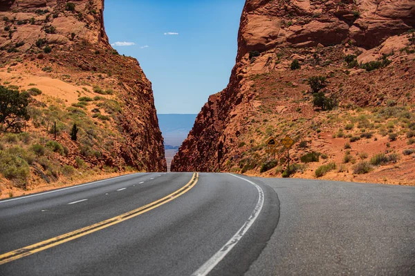 Un largo camino recto que conduce hacia una montaña rocosa. —  Fotos de Stock