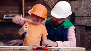 Baba ve oğul çekiç ve çivi çivisi kullanıyor. Çocuk Çocuk, evde inşaat işinde babasına yardım ediyor..