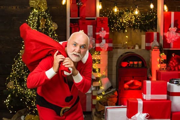 산타 클로스의 크리스마스 선물 가방. 산타가 가방을 들고 마스크를 쓰고 있어. 산타클로스의 옷을 입고 붉은 가방을 들고 있는 노상 도둑. — 스톡 사진