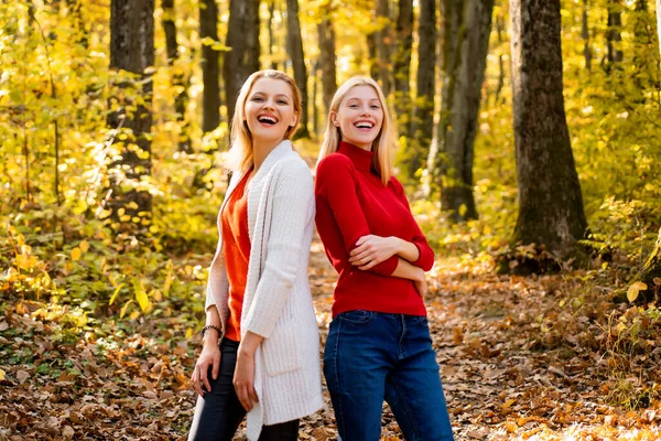 İki kız dışarıda sonbahar doğasının tadını çıkarıyor. Akçaağaç yapraklı kadın arkadaşlarının portresi. — Stok fotoğraf