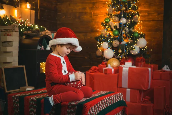 Julattribut. Den nuvarande lådan. Barndoms ögonblick. Julgran. Julinredning. En liten pojke som dekorerar julgranen och öppnar julklappar. Julklappar. — Stockfoto
