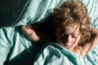 Tatlı çocuk yatakta uyuyor ve sabahları dinleniyor..