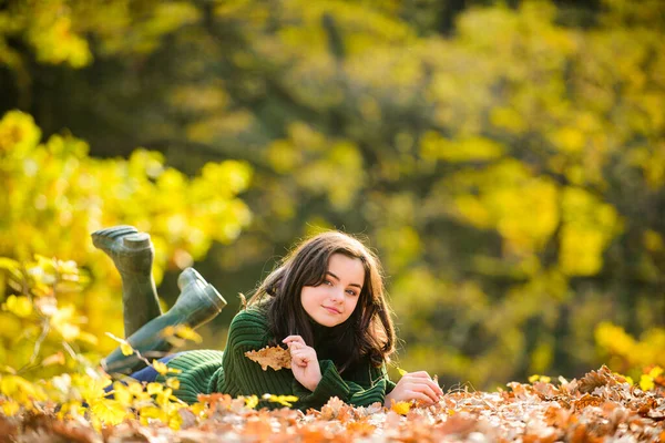 Menina adolescente sorridente deitada em folhas amarelas no outono. Adolescente de outono em folhas. — Fotografia de Stock