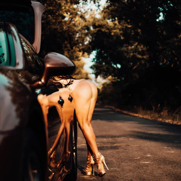 Sensual seductive young womans buttocks. Ideal womans butt, posing on car background. — Stockfoto