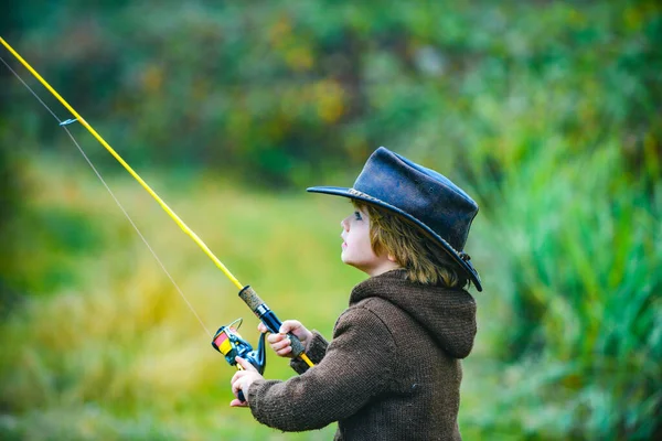 Kind mit Angel am See. Kleiner Junge fängt einen Fisch. Einsames glückliches kleines Kind, das aus einem Badesee oder Teich fischt. Foto von Kindern beim Angeln am Wochenende. — Stockfoto