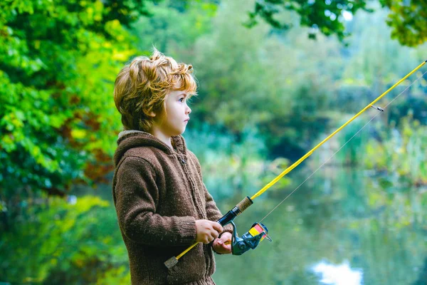 Retrato de niño lindo pesca niño. Niño con carrete giratorio. —  Fotos de Stock