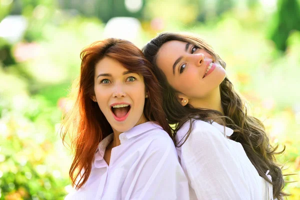 Twee jonge vriendinnen samen te voet. Portret van mooie jonge vrouwen op zoek naar camera in het park. — Stockfoto