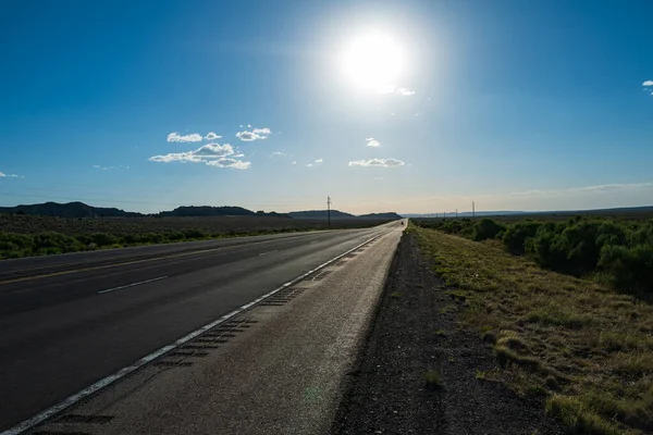 Vista panorâmica clássica de uma estrada reta sem fim que atravessa a paisagem estéril do sudoeste americano. — Fotografia de Stock