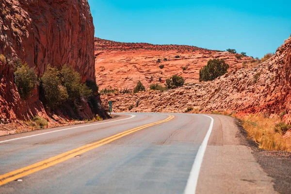 Strada contro le alte rocce. Long Desert Highway California. — Foto Stock