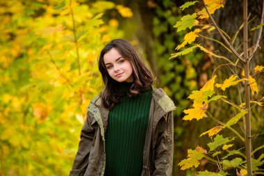 Güzel genç kız güneşli bir sonbahar gününün tadını çıkar..