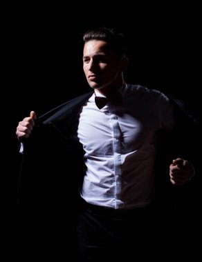 Stüdyoda takım elbise ve papyon takan kendine güvenen yakışıklı bir adam. Moda papyonu. Gömlekli yakışıklı bir adamın portresi..