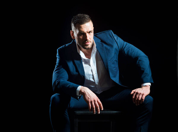 Уверенный в себе элегантный красивый молодой бизнесмен в студии в костюме.