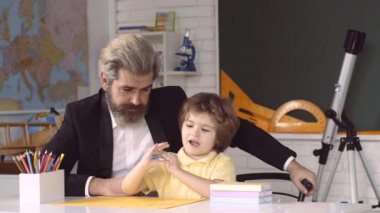 Eğitimli çocuklar. Baba ve oğul evde okuyor ve öğreniyor, çocuk yuvası eğitimi alıyor. Öğretmenler Günü.