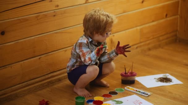 Niño para colorear. Linda niña mostrando sus manos pintadas en colores brillantes. Pinturas coloridas a mano. Educación, escuela, arte y painitng concepto. — Vídeos de Stock