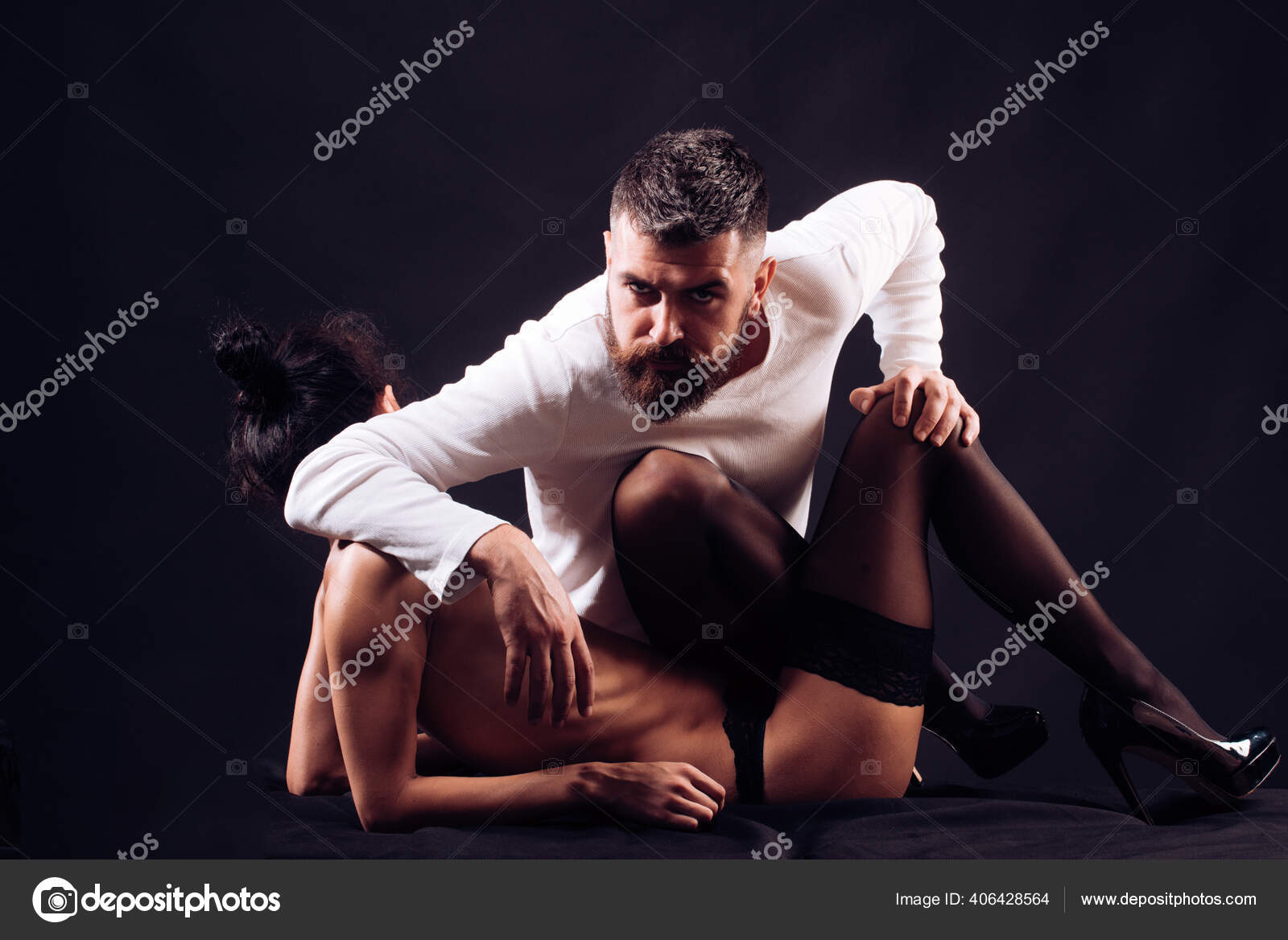 Bearded hipster macho man touching and foreplay with his sexy hot girlfriend wearing sexual black stocking at her beautiful long legs picture image