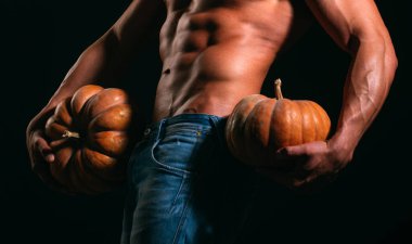 Cadılar Bayramı afişi. Seksi kaslı adam balkabağını tut.