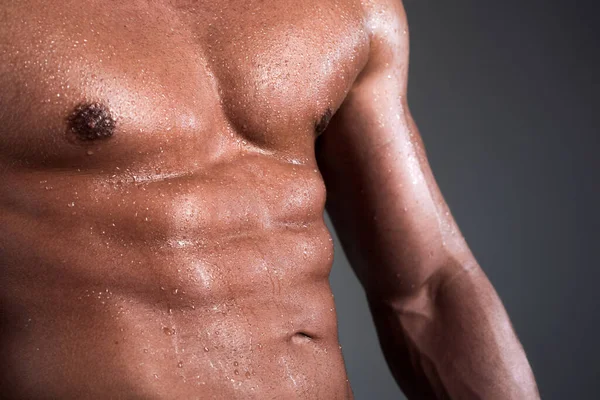 Atletik adam kaslarını kasıyor. Karın kasları, karın kasları, karın kasları. Seksi ve çıplak kaslı genç adam..