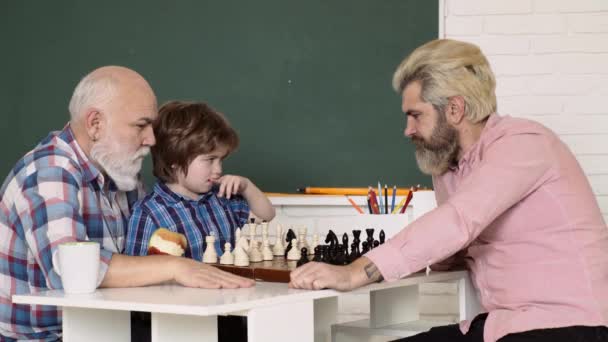 Ο παππούς και ο εγγονός παίζουν σκάκι στο σπίτι. Παιχνίδια και δραστηριότητες για παιδιά. Πρόωρη ανάπτυξη παιδιών. — Αρχείο Βίντεο