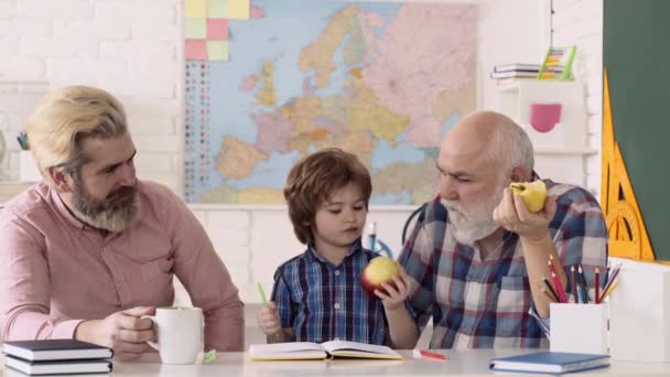 할아버지, 아버지, 아들이 실내에서 놀고 있습니다. 교육용 게임. 사립 학교 애들 이요. 사과를 먹는 학생. — 비디오