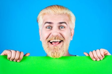 Boş kağıtlı mutlu adam. Reklamcılık. İş kavramı. İndirim. İş adamı elinde boş bir pankart tutuyor ve yere bakıyor.