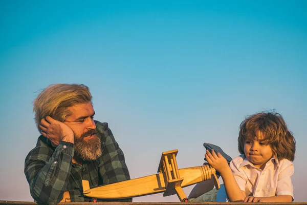 Padre e hijo jugando con avión de madera. — Foto de Stock