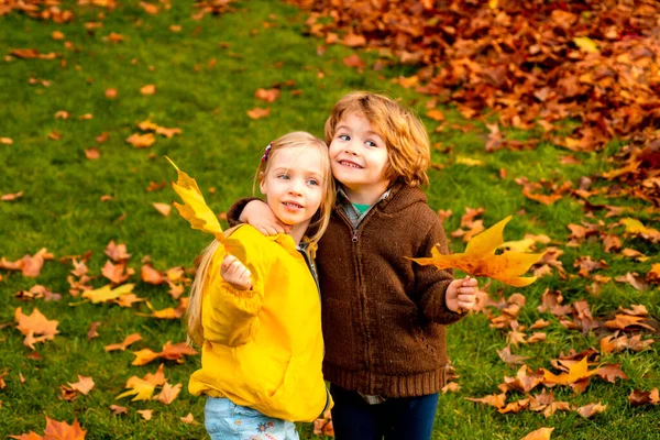 Amistosos niños y niñas románticos disfrutan del día de otoño en el parque. —  Fotos de Stock