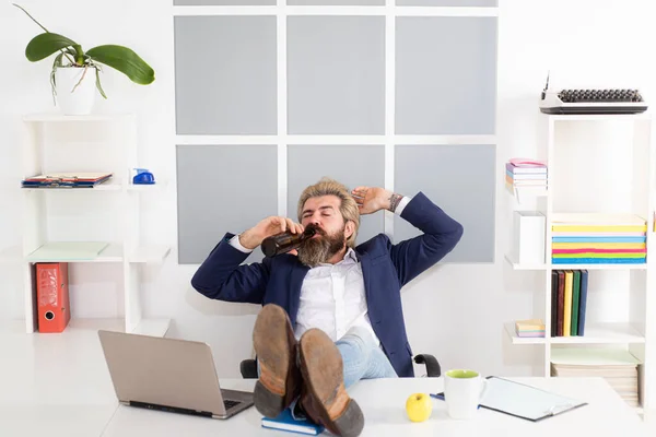 Un borracho al final de la jornada laboral. Empresario beber cerveza en su escritorio después de una fiesta en la oficina. — Foto de Stock