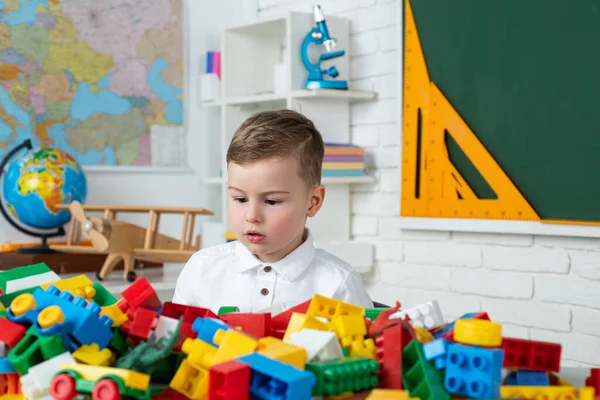 Kind spelen met kleurrijk speelgoed op de kleuterschool. Vroege ontwikkeling. De lagere school. Leerling. Leuke kleine jongen die studeert. — Stockfoto