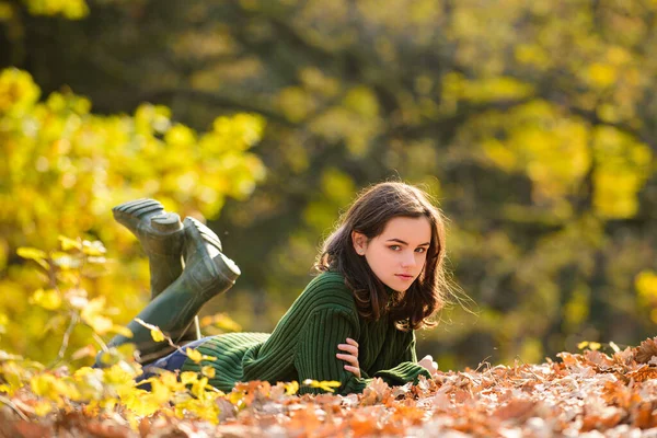 Adolescente autunnale su foglie. Ragazza adolescente su foglie di acero autunnali in autunno all'aperto. Ritratto di una bella adolescente. — Foto Stock