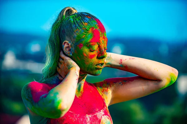 Multi colored face fully covered with bright holi paint. Colorful holi splash on body.